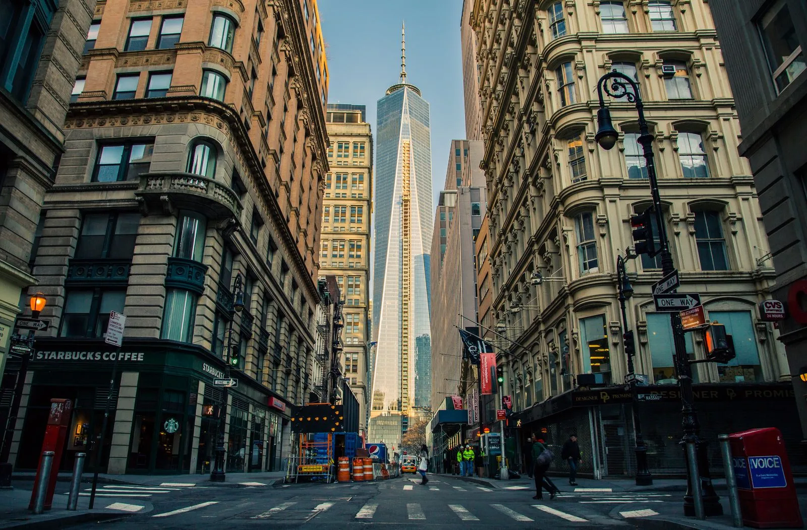 Rua do centro de Manhattan ao fim da tarde, com o One World Trade Center ao fundo